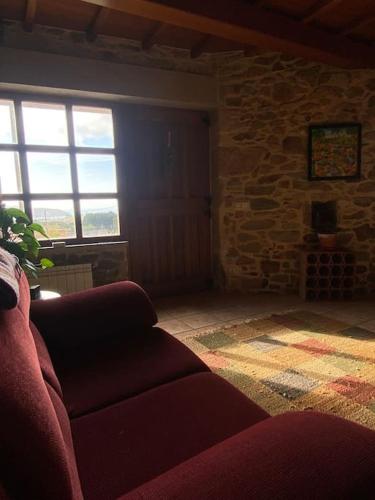 a living room with a couch and a stone wall at Casa do Souto in Ferrol
