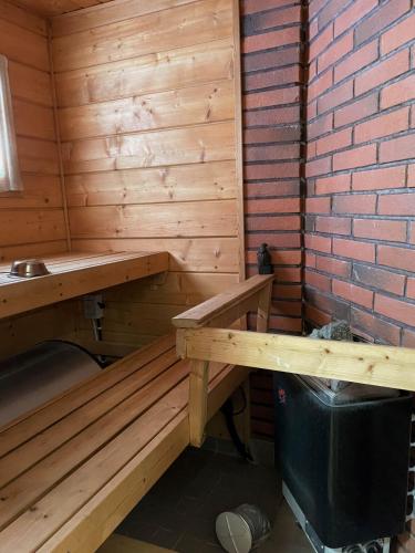 a wooden sauna with a bench and a sink at Koukun Kutsu in Kalajoki
