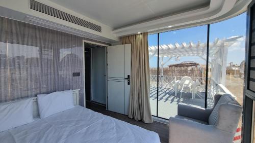 a bedroom with a bed and a balcony at Glam Beach Resort in Baku