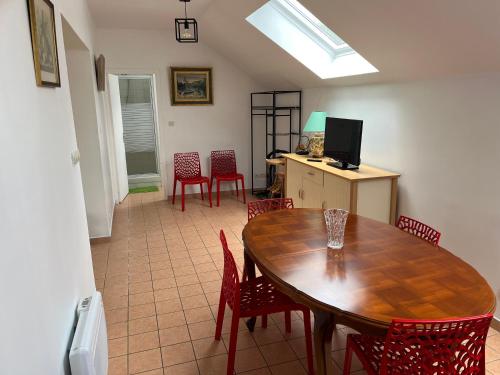 une salle à manger avec une table en bois et des chaises rouges dans l'établissement LA POMMERAIE, à Bosc-Bénard-Commin