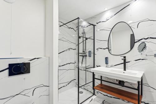 a bathroom with a sink and a mirror at Hôtel Akena Pierrelaye in Pierrelaye