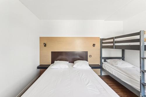 a bedroom with two bunk beds and a fireplace at Hôtel Akena Pierrelaye in Pierrelaye