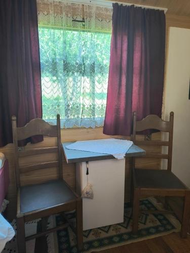 a room with two chairs and a table and a window at Poiana Stelelor in Văleni