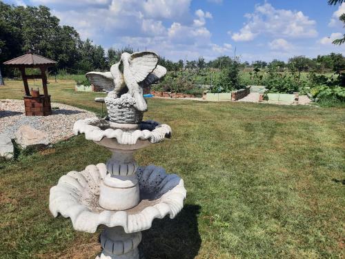 a statue of a bird bath in the grass at Bačalandia- relax na samote in Veľká Dolina