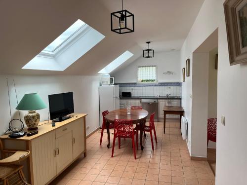 une cuisine et une salle à manger avec une table et un réfrigérateur dans l'établissement LA POMMERAIE, à Bosc-Bénard-Commin