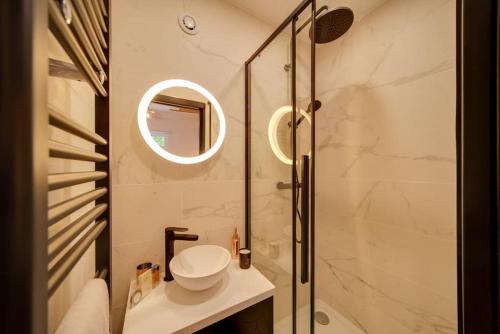 une salle de bain avec un lavabo et une douche avec un miroir dans l'établissement Stunning studio near Canal St Martin - DIVINE MOON, à Paris