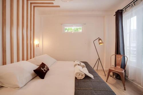 une chambre avec un lit blanc et une fenêtre dans l'établissement Stunning studio near Canal St Martin - DIVINE MOON, à Paris