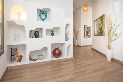 a room with a wall filled with vases and paintings at Hotel Ristorante S'Astore in Benetutti