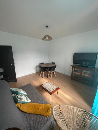 un salon avec un canapé et une table dans l'établissement Charmant appartement au Paradis, à Romagnat