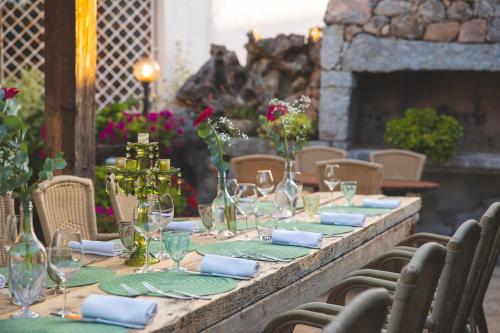a long table with wine glasses and napkins on it at Hotel Ristorante S'Astore in Benetutti