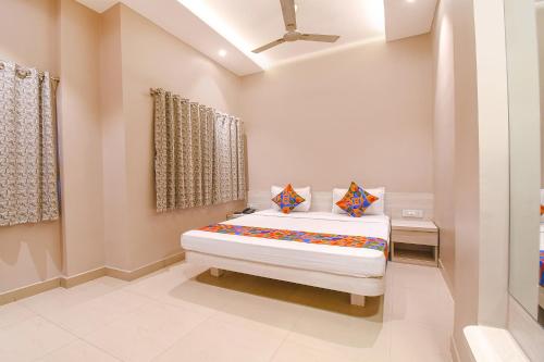 Un dormitorio con una cama con dos almohadas encima. en FabHotel Kitchen Q Inn - Belaghata, en Calcuta