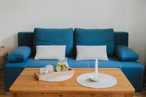 a blue couch with two pillows and a table at Lesny Dwór w Górach Sowich in Wolibórz