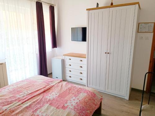 a bedroom with a bed and a dresser at Katalin Vendégház in Gyenesdiás