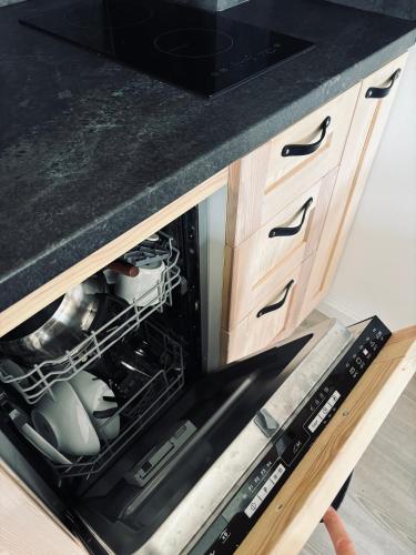 an open oven with dishes in it in a kitchen at Apartmány Panorama Harrachov in Harrachov