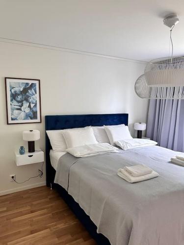 a bedroom with a large bed with a blue headboard at Nybyggd villa med sjönära läge in Dvärsätt