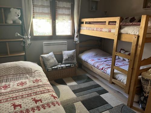 a bedroom with two bunk beds and a chair at La Taniere in Blachière