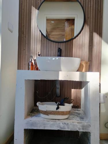 a bathroom with a white sink and a mirror at Alto Curanipe in Pelluhue
