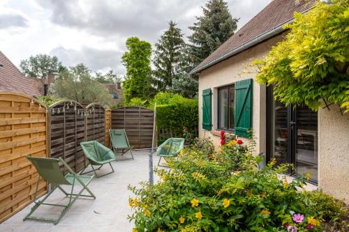 a patio with chairs and flowers and a fence at Le Moulin de Dannemarie in Dannemarie