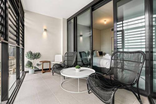 une chambre d'hôtel avec un lit, une table et des chaises dans l'établissement Stylish 2 Bed in Central CBD with Pool & Gym, à Sydney