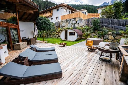 un patio avec des chaises et une table sur une terrasse en bois dans l'établissement ChaletSerlesblickTIROL, à Mieders
