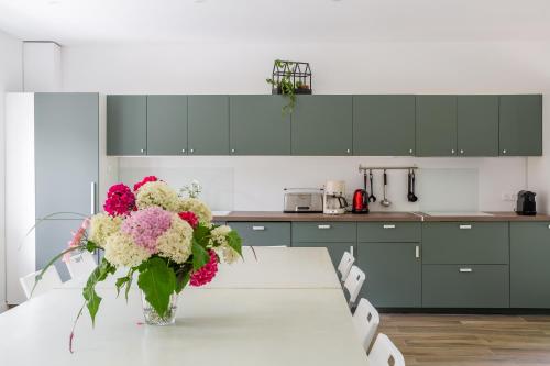 a kitchen with a table with a vase of flowers at Le Moulin de Dannemarie in Dannemarie