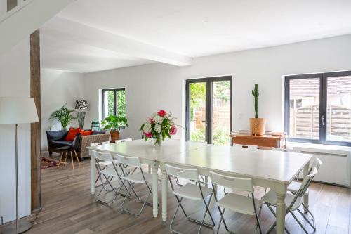 a white dining room with a white table and chairs at Le Moulin de Dannemarie in Dannemarie