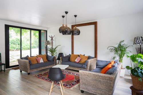 a living room with two couches and a table at Le Moulin de Dannemarie in Dannemarie