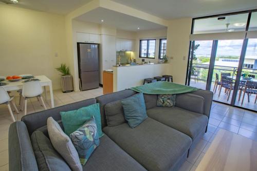 a living room with a couch and a kitchen at Sitting on the Dock of the Bay in Stuart Park