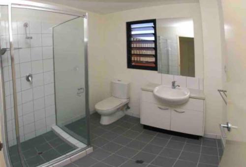 a bathroom with a shower and a toilet and a sink at Sitting on the Dock of the Bay in Stuart Park
