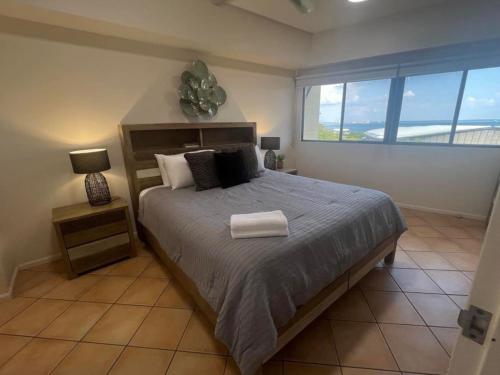 a bedroom with a large bed and a large window at Darwin Esplanade Walk to Waterfront Wines and Waves in Darwin