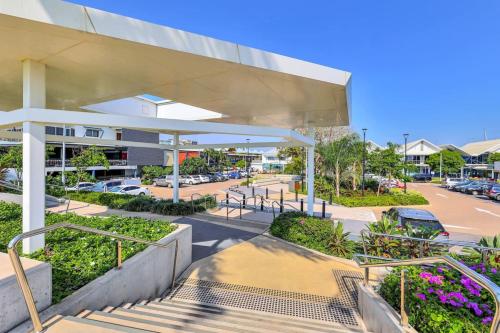 a building with stairs in front of a parking lot at Watch the Sun set over Cullen Bay Marina and Harbour in Larrakeyah