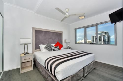 a bedroom with a large bed and a window at Light and Spacious CBD Apartment with Ocean views in Darwin