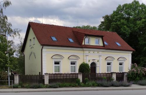 a small white house with a red roof at Zámecká pošta penzion in Neznašov