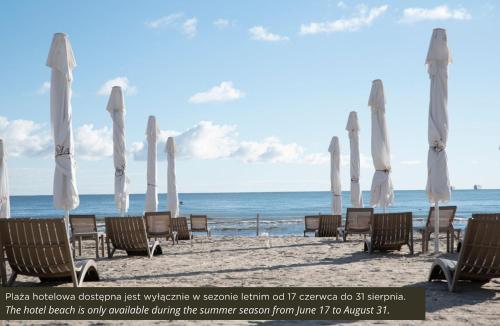 a group of umbrellas and chairs on a beach at Hotel Haffner Resort & Spa - Destigo Hotels in Sopot