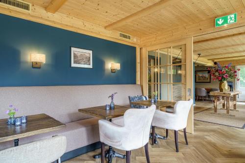 a dining room with a table and white chairs at Boutique Hotel Panorama Grindelwald in Grindelwald