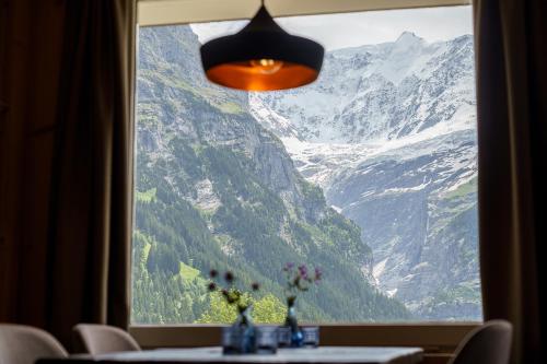a window with a view of a mountain view at Boutique Hotel Panorama Grindelwald in Grindelwald