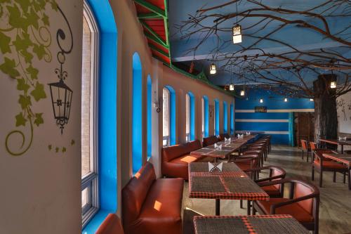 a restaurant with tables and chairs and blue walls at Devi Enterprises - Hotel Khems in Ooty