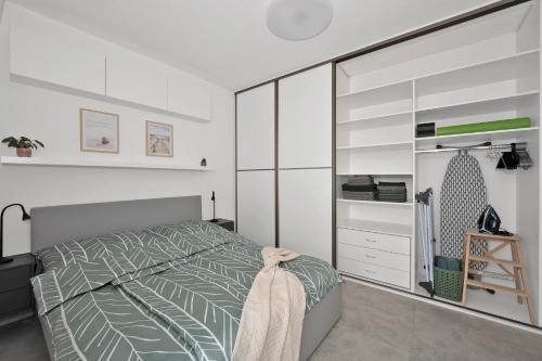 a bedroom with a bed and a large closet at Fully equipped Apartments with Terraces, Free garage parking, Netflix & AC - by Apartmány Šlapanice cz in Šlapanice