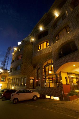 a white car parked in front of a building at night at Devi Enterprises - Hotel Khems in Ooty