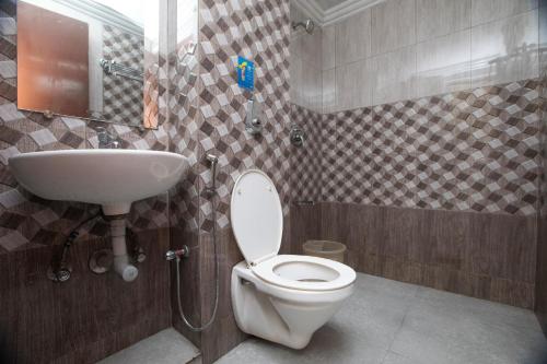 a bathroom with a toilet and a sink at Devi Enterprises - Hotel Khems in Ooty