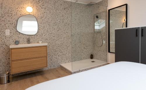 - une chambre avec un lavabo et un miroir dans l'établissement Cœur de Metz Balnéo - La Suite 4, à Metz