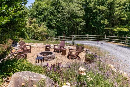 a garden with chairs and a fire pit on the side of a road at Mountaineer Manor in Sugar Grove