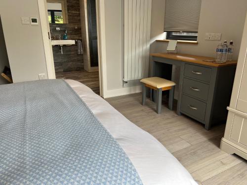 a bedroom with a bed and a desk and a kitchen at Seafront BnB at Botany in Kent
