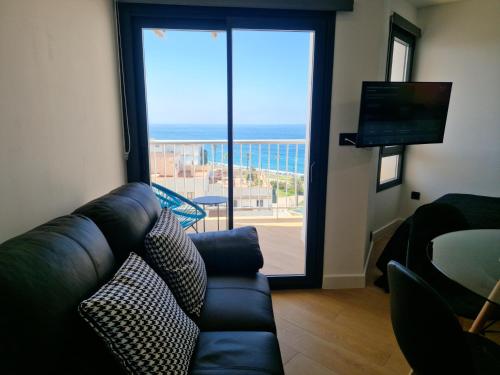 Una sala de estar con un sofá y vista al mar. en Estudio 8, en Salobreña