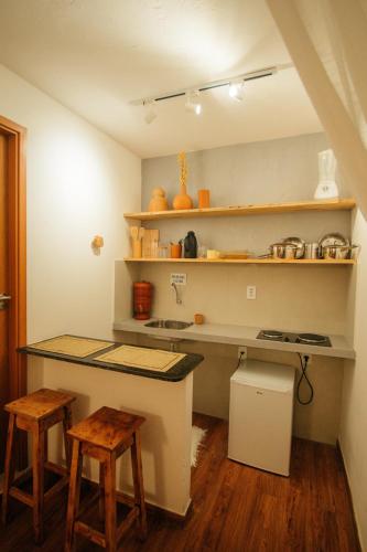 a kitchen with a counter and stools in a room at Pousada Girassol Morro de São Paulo in Morro de São Paulo