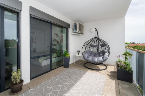 a room with a swing on a balcony at Fully equipped Apartments with Terraces, Free garage parking, Netflix & AC - by Apartmány Šlapanice cz in Šlapanice