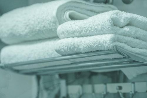 a pile of white towels sitting on a rack at Haris Apartments Tirana in Tirana