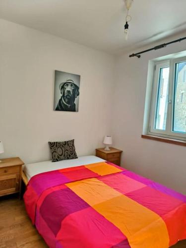 a colorful bed in a bedroom with a window at Romantic Apartment Sonvico in Lugano