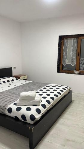 a bed with a black and white comforter in a room at Casa Haidu in 2 Mai