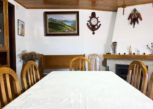 a dining room with a table and a clock on the wall at Sobrado Fonseca in Paredes do Rio
